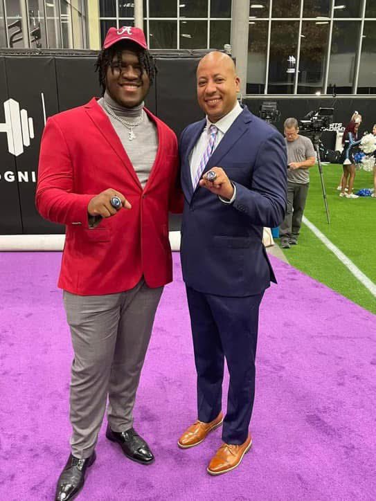 Coach Acosta with Alabama player and championship rings